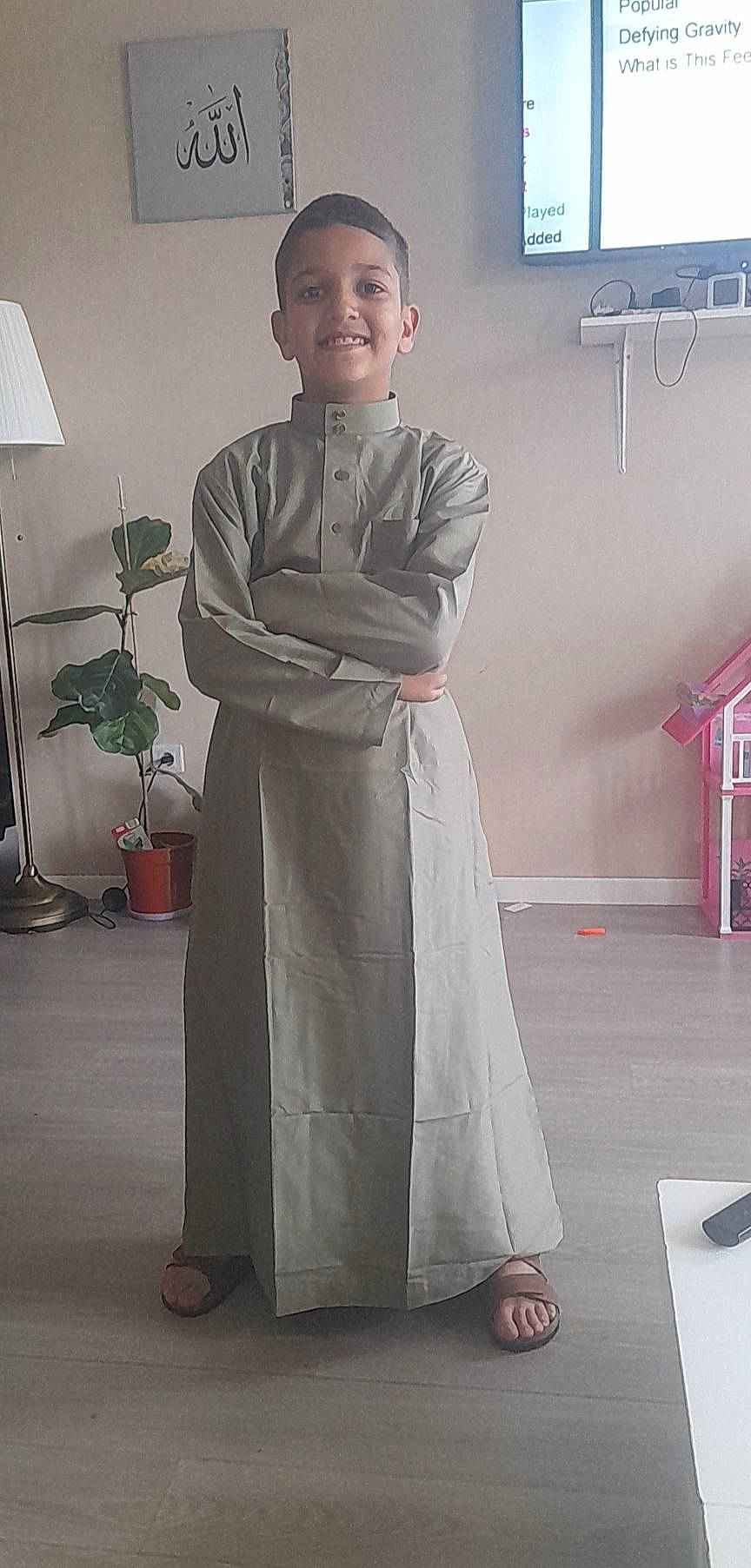 Yanis participe au concours pour gagner de l'argent avec cette photo : child, costume, event, fashion_design, flooring, flowerpot, formal_wear, houseplant, joy, lamp, person, plant, room, sandal, sleeve, smile, t_shirt, uniform