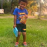 Amarion joined the competition — help win amazing prizes! black_shorts, blue_shirt, boy, casual_clothing, child, chips, grass, happy, hot_wheels, lay's, nature, outdoor, slippers, smiling, snack, spiderman, standing, sunlight, toy, trees