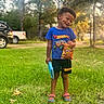 Amarion is registered to the contest to win money with this photo: black_hair, blue_shirt, boy, child, chips, grass, happy, hot_wheels, lays, nature, outdoor, playful, shoes, shorts, smiling, spiderman, sunlight, toddler, toy, trees