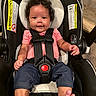 baby, child, car_seat, curly_hair, smiling, pink_shirt, blue_pants, feet, infant, seatbelt, portrait, indoors, cute, safety_harness, person, happy, closeup, young_child, head_support, foot