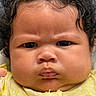 Avery is registered to the contest to win money with this photo: baby, child, chubby_cheeks, close_up, curly_hair, cute, eyebrows, face, headshot, human, indoors, infant, looking_at_camera, natural_light, person, portrait, serious_expression, skin, yellow_clothing, young