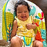 baby, baby_seat, bright_colors, child, colorful, comfort, curly_hair, cute, floor, happy, indoor, infant, joyful, patterned, playful, seatbelt, skin, smiling, toddler, yellow_dress
