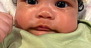 Avery joined the competition — help win amazing prizes! baby, closeup, face, curly_hair, big_eyes, blanket, green_clothing, infant, portrait, skin, child, cute, young, indoors, expression, looking_at_camera, person, head, newborn, soft_light