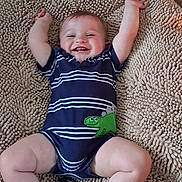 Jack joined the competition — help win amazing prizes! baby, infant, child, smiling, happy, lying_down, arms_raised, portrait, striped_outfit, navy_clothing, crocodile_design, green_crocodile, textured_rug, indoor, close_up, face, eyes, mouth, bare_legs, socks