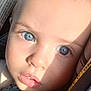 Maxieum is registered to the contest to win money with this photo: baby, blue_eyes, close_up, car_seat, child, face, infant, light, sunlight, warning_label, young_child, portrait, skin, eyebrows, nose, mouth, clothing, zipper, seatbelt, expression