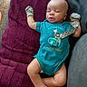 baby, infant, sleeping, portrait, indoors, blanket, couch, blue_outfit, onesie, mittens, pacifier, pacifier_clip, text_on_clothing, burgundy_blanket, relaxed, peaceful, sitting, lying_down, close_up, child