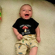 A J joined the competition — help win amazing prizes! baby, barefoot, blanket, casual, close_up, clothing, cozy, face, happy, indoor, infant, lying_down, mushroom, onesie, plush_texture, portrait, shirt_text, shorts, skin, smiling