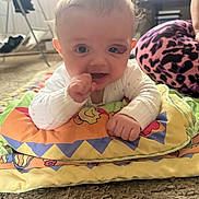 Romeo joined the competition — help win amazing prizes! baby, infant, child, play_mat, colorful, thumb_sucking, curious, carpet, indoor, person, clothing, purple_pants, patterned_pants, floor, radiator, window, toys, home, cute, expression
