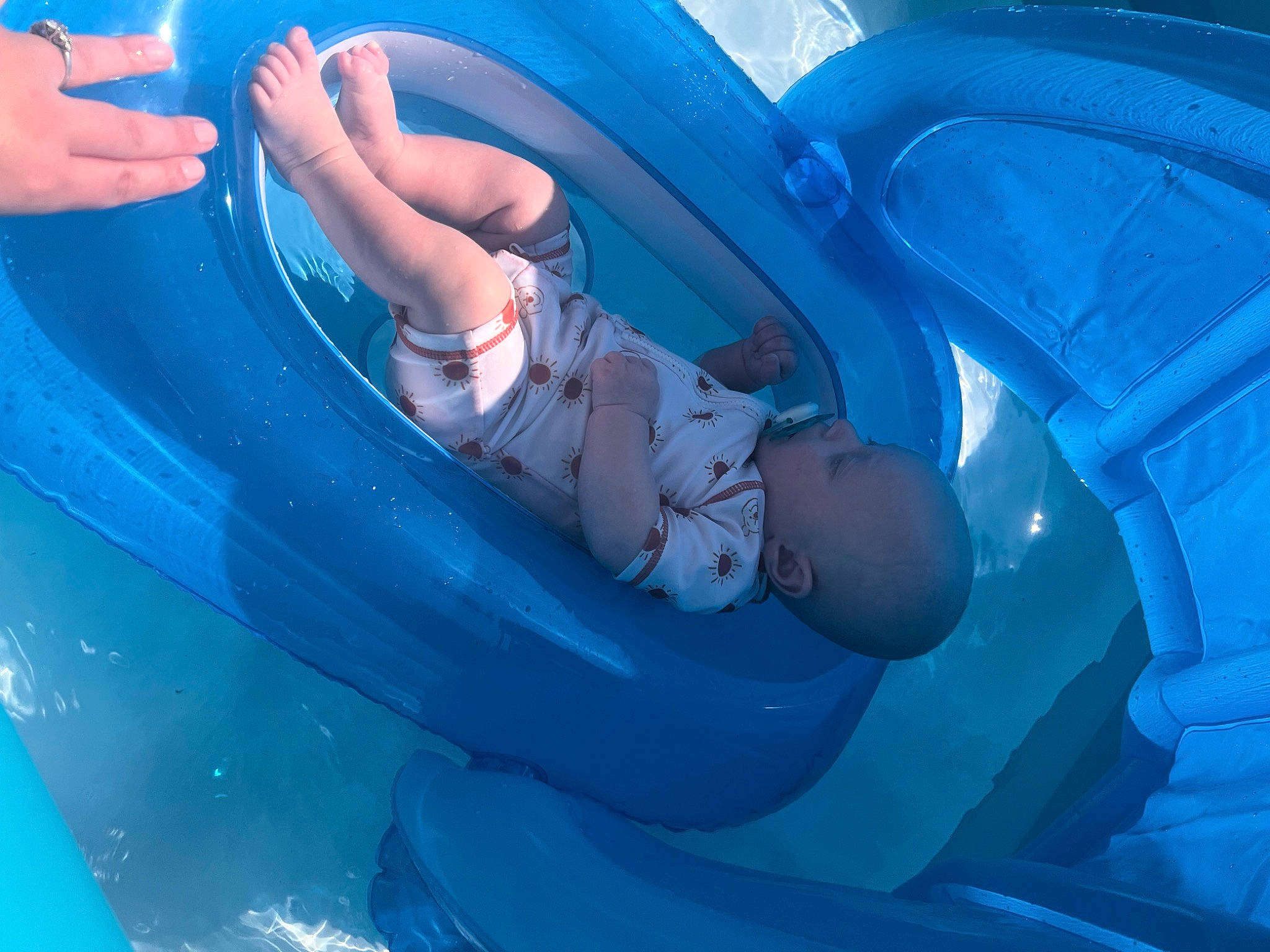 Malaki is registered to the contest to win money with this photo: aqua, baby, bathing, blue, child, circle, comfort, electric_blue, fun, human_leg, inflatable, knee, leg, leisure, person, plastic, recreation, smile, thigh, toddler