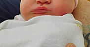 Delta is registered to the contest to win money with this photo: baby, blanket, child, closeup, clothing, cute, expression, face, hand, hat, headwear, indoors, infant, newborn, newborn_baby, person, pouting, skin, soft, swaddled