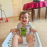 Doron a rejoint le concours — aidez-le/la à gagner de superbes lots ! child, clothing, cute, diaper, face, floor, furniture, hair, happy, home, indoor, laundry_basket, person, plastic, playful, red_tablecloth, sitting, smiling, table, toddler