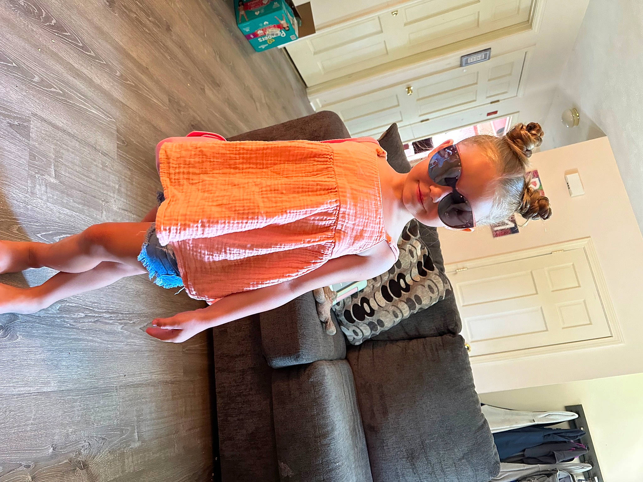 Brynnleigh is registered to the contest to win money with this photo: child, comfort, door, elbow, eyewear, fashion_design, flesh, flooring, fun, hardwood, human_leg, pattern, peach, person, room, thigh, waist, wood, wrist