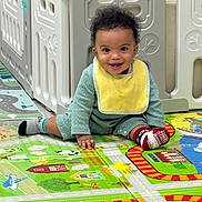 Zaedyn joined the competition — help win amazing prizes! baby, child, smiling, playmat, crawling, curly_hair, bib, socks, indoor, playpen, colorful, floor, cute, happy, person, toddler, toy, home, young_child, fun