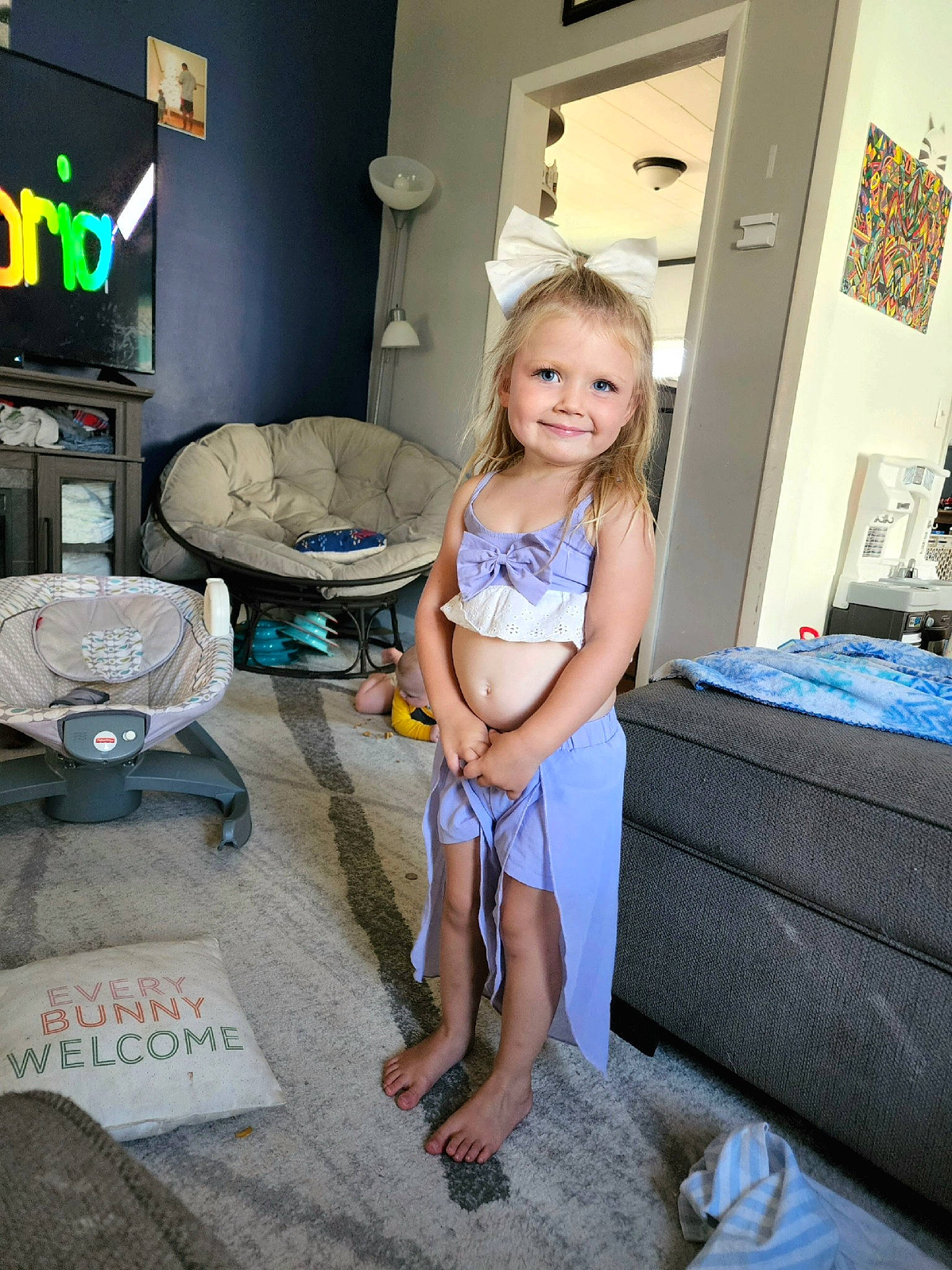 Aubrielle is registered to the contest to win money with this photo: child, drawer, floor, flooring, fun, hardwood, home_appliance, human_leg, joy, leisure, living_room, person, room, sandal, shorts, sitting, smile, standing, t_shirt, thigh