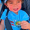 Lyndon is registered to the contest to win money with this photo: child, toddler, stroller, blue_shirt, cap, birthday_sticker, happy, outdoor, seatbelt, smile, face, hand, photography, person, baby, seat, clothing, colorful, daylight, portrait