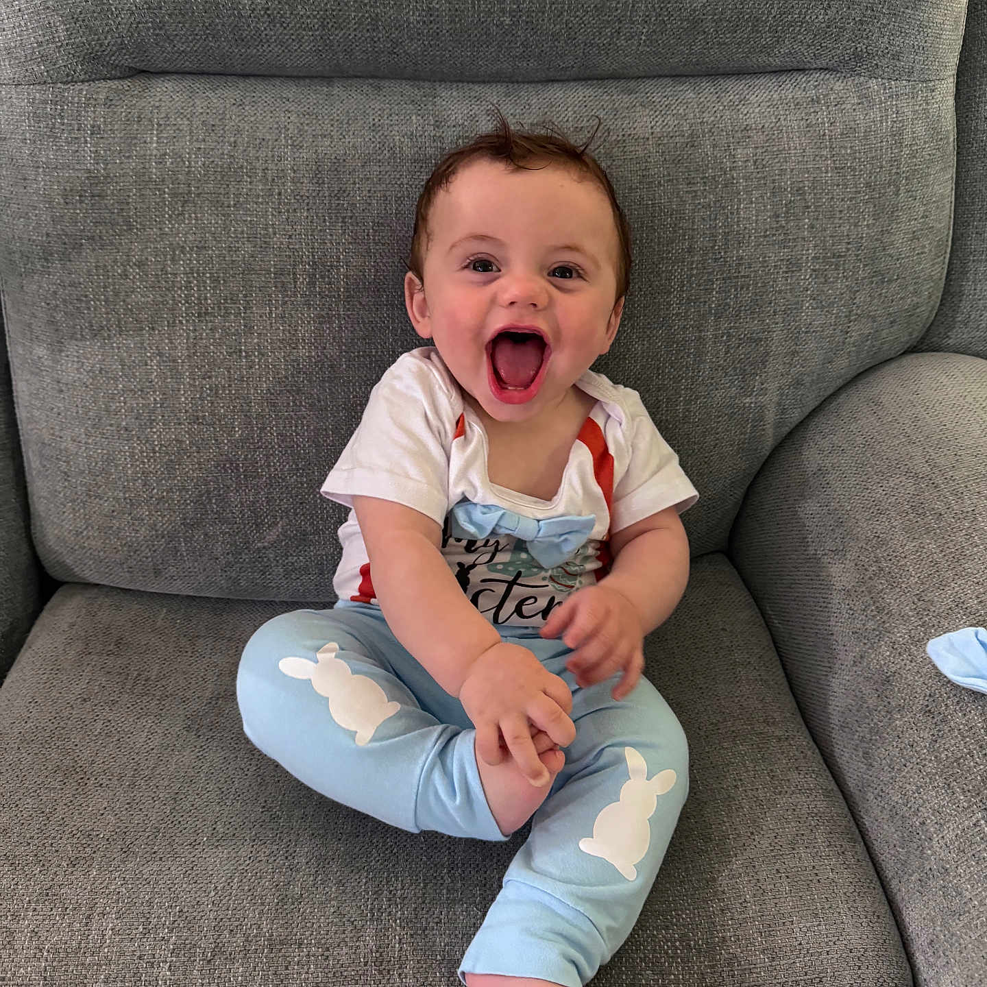 Atlas joined the competition — help win amazing prizes! baby, child, smiling, happy, sitting, couch, furniture, clothing, pants, shirt, blue, white, bunny, bow, face, expression, indoors, person, cute, joy