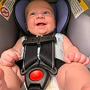 Augustine joined the competition — help win amazing prizes! baby, car_seat, smiling, infant, safety_harness, happy, child, seatbelt, cute, closeup, person, padding, warning_label, indoors, cheerful, wearing_clothes, infant_clothing, head_support, expressive_face, human