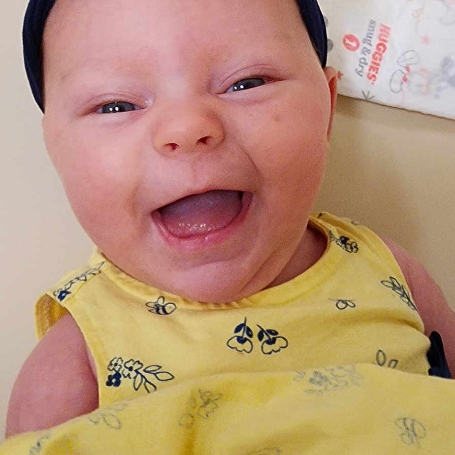 Olivia is registered to the contest to win money with this photo: accessories, baby, babylaughing, bodypart, clothing, dress, face, happy, hat, head, headband, jewelry, laughing, mouth, necklace, newborn, person, photography, portrait, smile