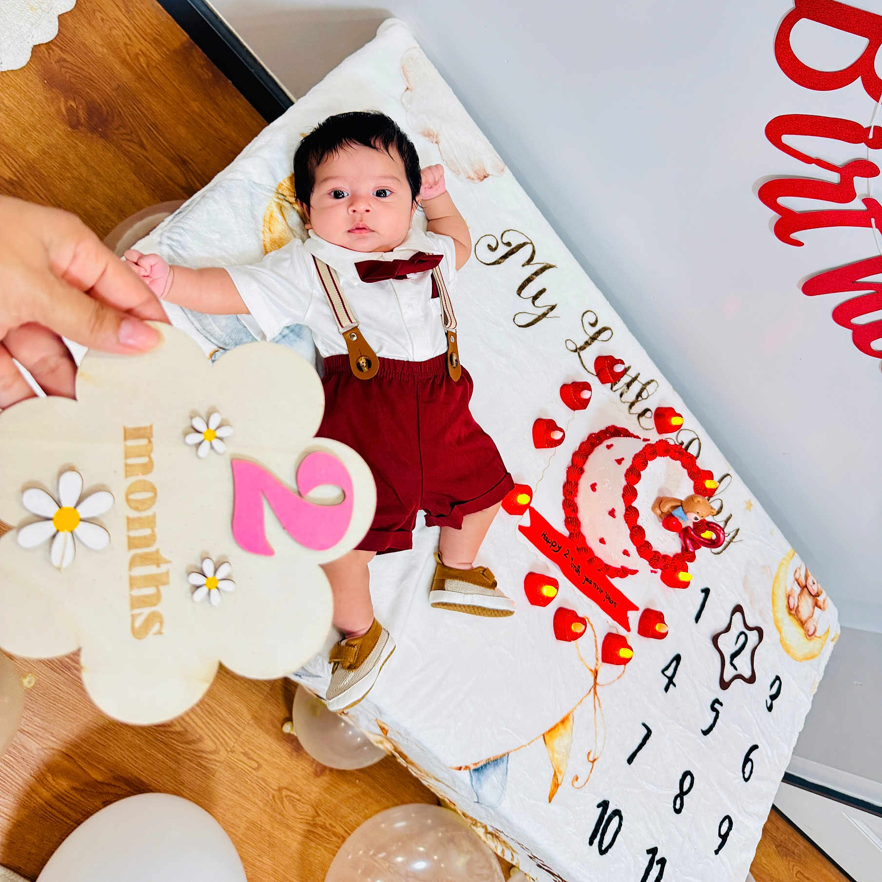 Jaanvir Johan joined the competition — help win amazing prizes! baby, infant, child, portrait, birthday, birthday_decorations, milestone_blanket, bow_tie, suspenders, red_shorts, tiny_shoes, lying_down, smiling, indoor, wooden_floor, balloons, hearts, flower_sign, cake, family_photo