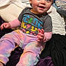 Athena joined the competition — help win amazing prizes! toddler, child, smiling, indoor, bed, blanket, colorful_clothing, pants, shirt, face, happy, person, foot, hand, toy, cozy, room, casual, seated, young_child