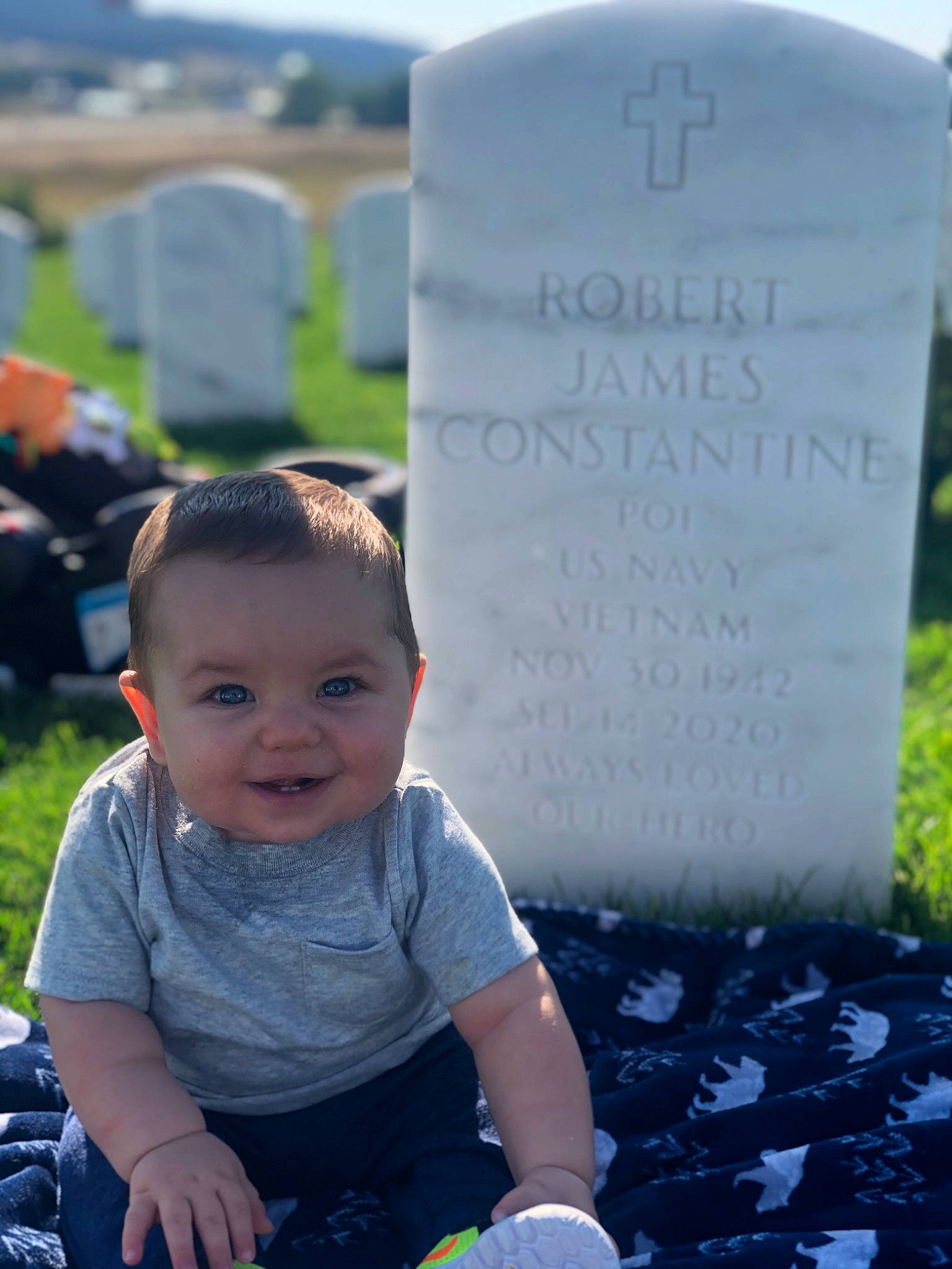 James Wayne is registered to the contest to win money with this photo: baby, baby_toddler_clothing, black, cemetery, child, electric_blue, grass, grave, handwriting, happy, headstone, morning, people, person, photograph, plant, sky, smile, snapshot, summer
