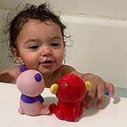 Anthony joined the competition — help win amazing prizes! toddler, child, bathtub, bath_time, toy, plastic_toy, curly_hair, wet_hair, playing, water, cute, smiling, indoor, white_tub, pink_toy, red_toy, yellow_ears, purple_details, face, hand