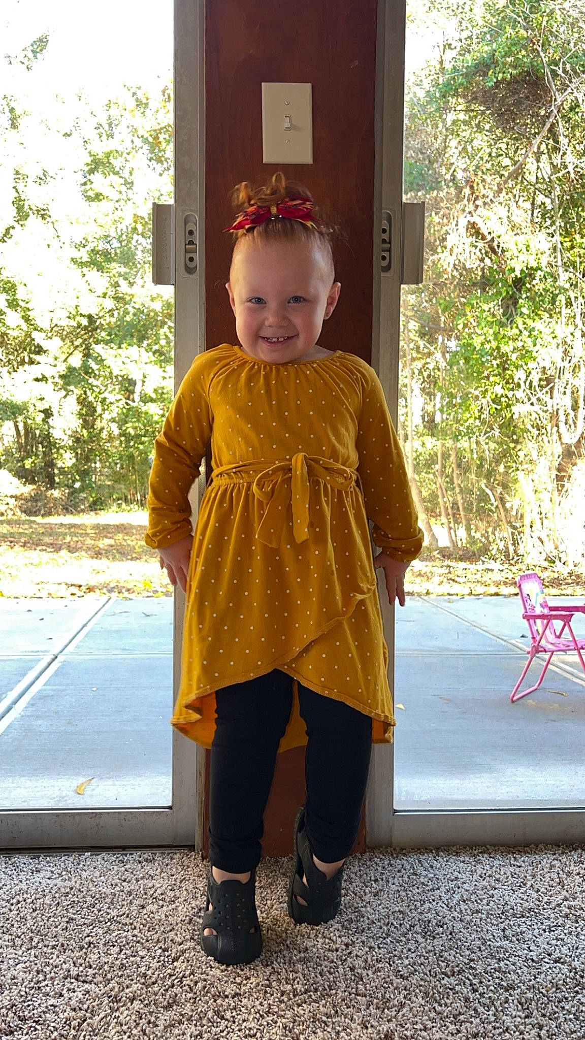 Addilynn is registered to the contest to win money with this photo: baby_toddler_clothing, child, face, fashion_accessory, formal_wear, fun, grass, happy, human_leg, joy, knee, leisure, magenta, pattern, person, personal_protective_equipment, plant, sleeve, smile, toddler