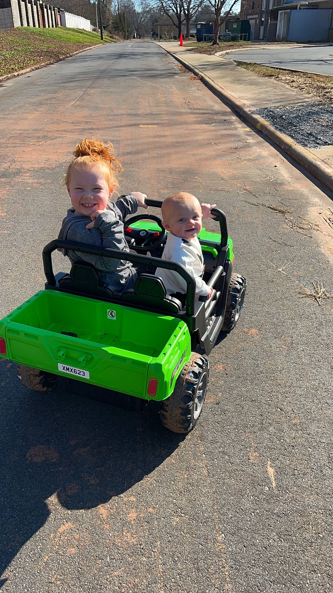 Maisley is registered to the contest to win money with this photo: asphalt, auto_part, automotive_design, automotive_exterior, automotive_tire, automotive_wheel_system, baby, bumper, child, fender, grass, joy, motor_vehicle, person, road_surface, rolling, tire, toddler, tractor, tread