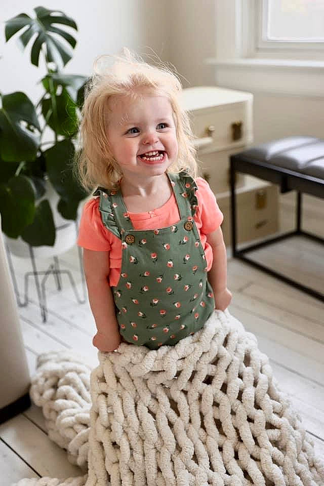 Jacqueline is registered to the contest to win money with this photo: arm, baby_toddler_clothing, blond, child, clothing, flooring, fun, green, hair, hairstyle, happy, head, joy, person, plant, skin, sleeve, smile, standing, toddler