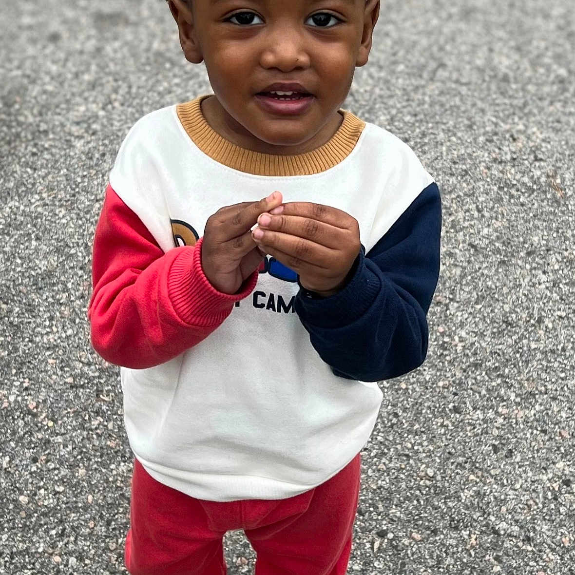 Kashton joined the competition — help win amazing prizes! toddler, child, curly_hair, pigtails, sweatshirt, red_pants, boots, outdoor, gravel, standing, looking_up, hands_together, casual_clothing, cute, young_child, curious_expression, colorful_clothes, portrait, person, daylight