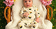 Malikai is registered to the contest to win money with this photo: baby, infant, basket, knitted_blanket, flowers, yellow_flowers, pink_flowers, grass, outdoor, sushi_pajamas, hat, cute, portrait, child, nature, greenery, cozy, wicker, sitting, person