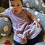 baby, infant, child, headband, bow, striped_dress, leggings, cushion, cloud_pattern, toy, floor, wooden_floor, indoor, person, sitting, tongue_out, cute, chubby_cheeks, comfort, home