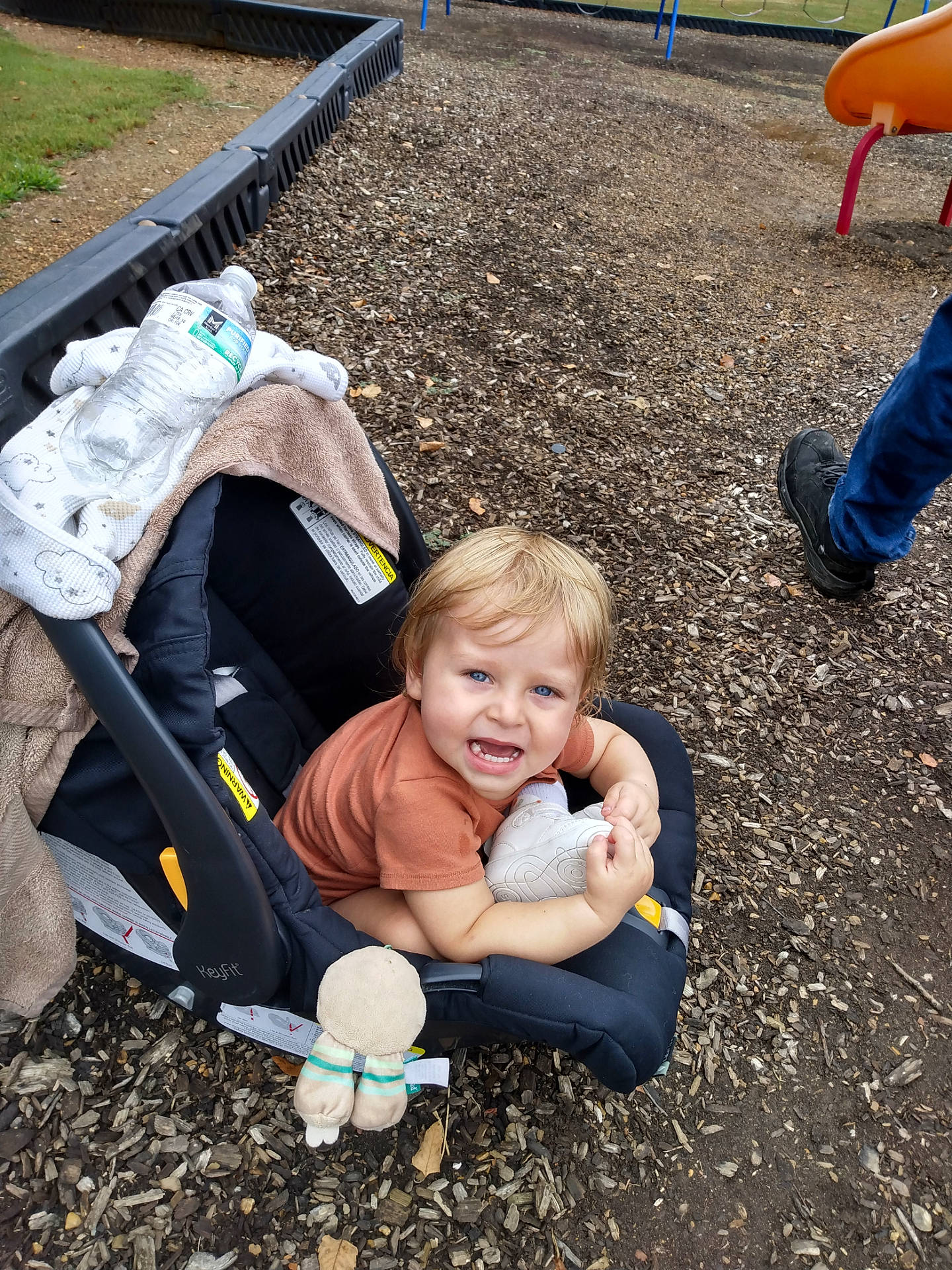 Elijah joined the competition — help win amazing prizes! baby, black_shoes, blanket, blue_eyes, car_seat, child, clothing, grass, happy, jeans, outdoor, person, playground, seat, shoe, smile, toddler, toy, water_bottle, wood_chips