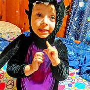 Elijah joined the competition — help win amazing prizes! bed, bedding, bedroom, black, child, colorful, costume, curious, curtain, cute, dragon, hands, indoor, peace_sign, person, playful, purple, smile, space_theme, wood_paneling