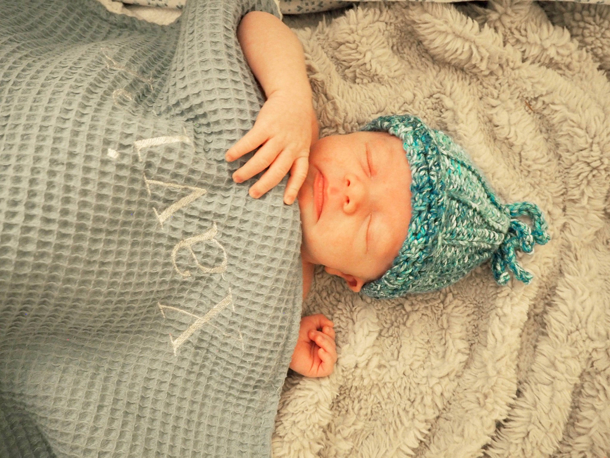 Xavier is registered to the contest to win money with this photo: abdomen, baby, baby_products, baby_toddler_clothing, child, comfort, elbow, gesture, headwear, linens, nail, pattern, person, skin, sleeve, textile, thumb, toddler, wood, wool