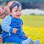 toddler, child, grass, blue_clothing, smile, outdoor, person, sitting, happy, casual_wear, daylight, portrait, young_child, jacket, shoes, sock, hand, support, nature, greenery