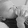 baby, bottle, feeding, infant, close_up, black_and_white, hand, face, blanket, newborn, child, portrait, indoors, soft_texture, young, candid, peaceful, resting, cute, expression