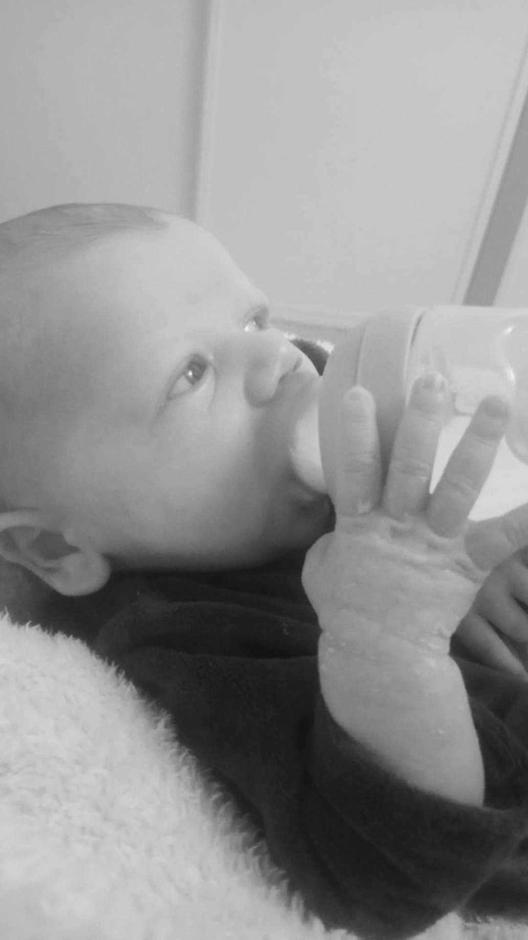 Ethan a rejoint le concours — aidez-le/la à gagner de superbes lots ! baby, bottle, feeding, infant, close_up, black_and_white, hand, face, blanket, newborn, child, portrait, indoors, soft_texture, young, candid, peaceful, resting, cute, expression