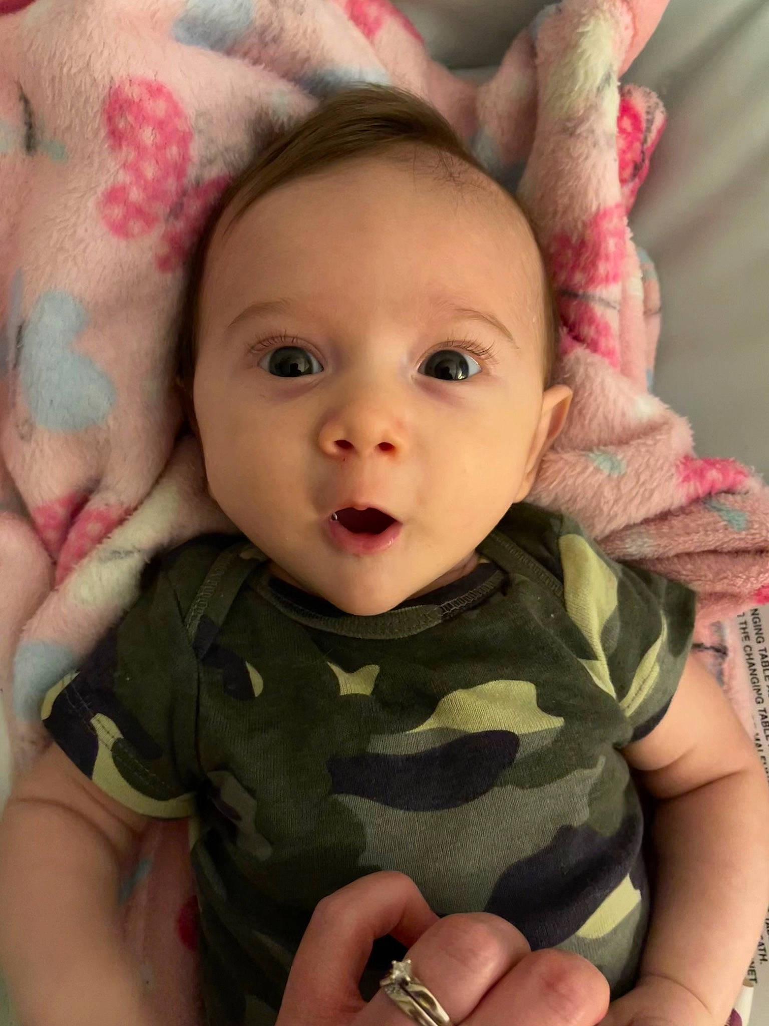 Luke is registered to the contest to win money with this photo: baby, baby_toddler_clothing, cheek, chin, eye, eyebrow, eyelash, face, facial_expression, finger, gesture, happy, head, iris, lip, mouth, nose, person, pink, skin