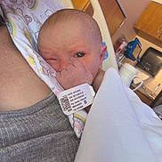 Summer is registered to the contest to win money with this photo: newborn, baby, infant, hospital, blanket, hospital_bed, id_bracelet, person, hand, face, skin, clothing, adult, medical, room, furniture, nursing, care, hospital_room, rest