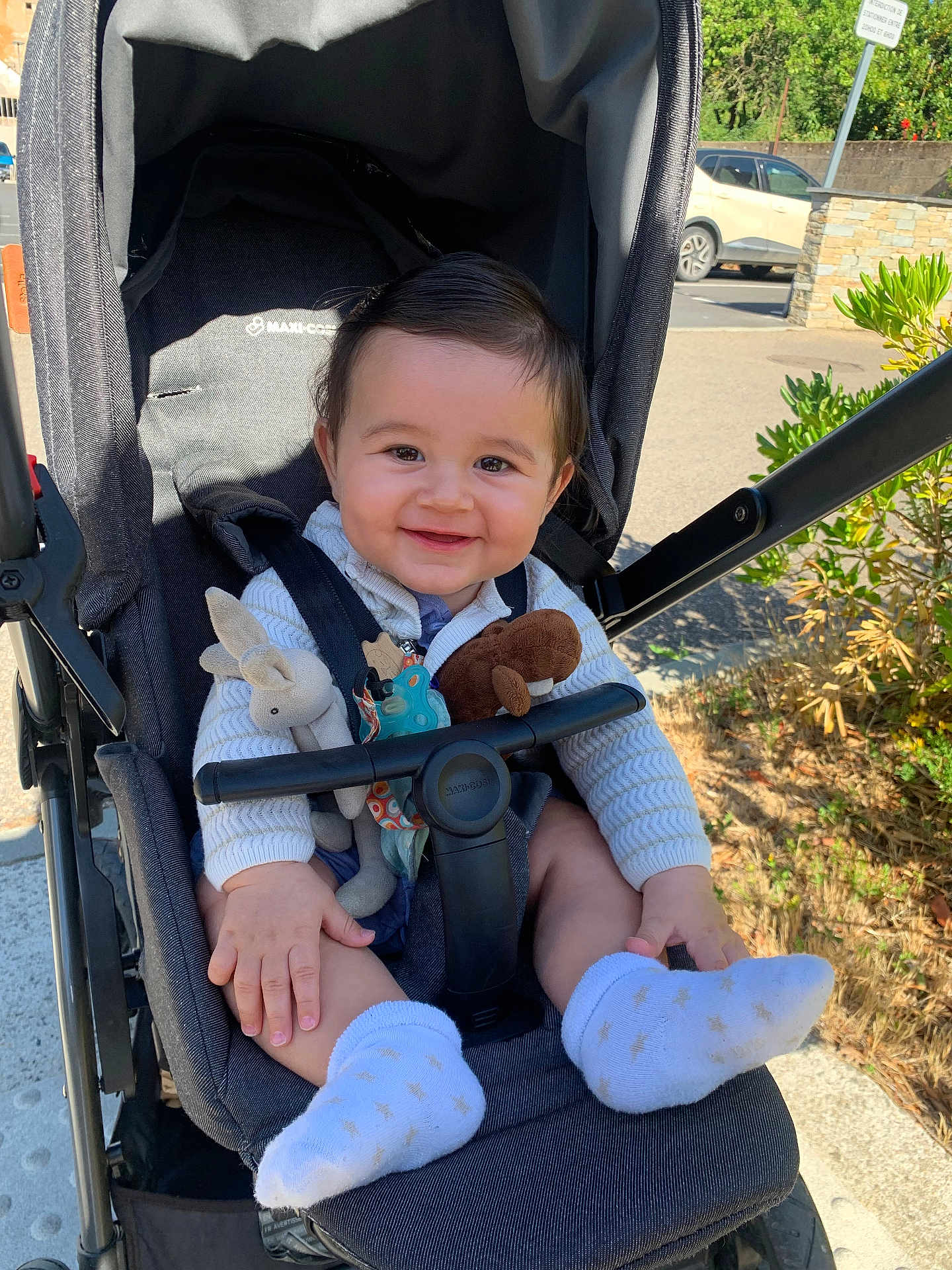 Marceau a rejoint le concours — aidez-le/la à gagner de superbes lots ! baby, baby_toys, casual, child, clothing, cute, greenery, happy, infant, nature, outdoor, parked_car, person, seat, smiling, sock, stroller, sunlight, toy, transport