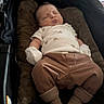 baby, infant, sleeping, stroller, portrait, cozy, white_onesie, brown_clothing, mittens, pants, socks, cushion, blanket, indoor, peaceful, resting, closed_eyes, face, child, photography