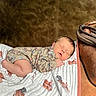 Cohen is registered to the contest to win money with this photo: newborn, baby, sleeping, infant, portrait, saddle, horse_equipment, blanket, outdoor, western, cowboy, rustic, peaceful, closed_eyes, onesie, patterned_clothing, resting, photography, animal_print, cozy