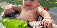 Malcolm is registered to the contest to win money with this photo: baby, smiling, outdoor, sunlight, baby_seat, greenery, trees, grass, happy, child, infant, nature, lawn, summer, seat, playtime, cute, person, relaxing, sunshine
