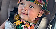 Shaddaimarie is registered to the contest to win money with this photo: baby, child, stroller, hat, bucket_hat, floral_pattern, colorful_clothing, seatbelt, infant, cute, portrait, smile, face, earrings, closeup, outdoor, sunlight, comfort, baby_seat, expression