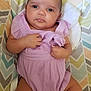 baby, chevron_pattern, child, cushion, cute, expression, fabric, face, hand, indoors, infant, legs, lying_down, newborn, person, portrait, purple_clothing, romper, skin, soft