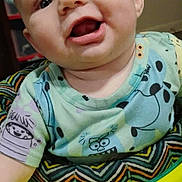 Tatum joined the competition — help win amazing prizes! baby, child, smiling, face, eyes, mouth, shirt, cartoon_print, colorful, sitting, yellow, baby_seat, indoor, closeup, happy, infant, person, skin, head, cheeks