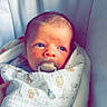 Luca joined the competition — help win amazing prizes! baby, blanket, child, cozy, cushion, cute, face, indoor, infant, newborn, pacifier, person, portrait, resting, seat, sleepy, small, soft, wrapped, young