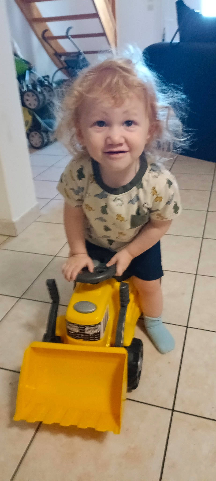 Noah participe au concours pour gagner de l'argent avec cette photo : baby, baby_toddler_clothing, cheek, child, cleanliness, face, floor, flooring, fun, joy, person, plastic, riding_toy, sitting, skin, sleeve, smile, tire, toddler, toy
