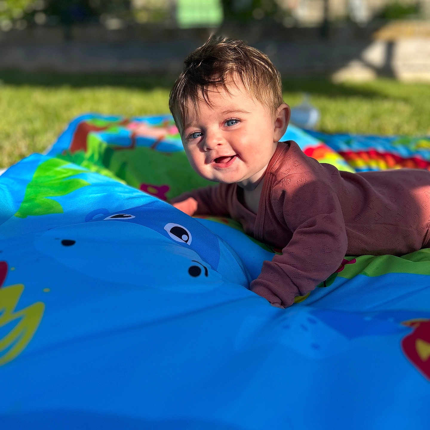 Inaya participe au concours pour gagner de l'argent avec cette photo : baby, blue_eyes, child, clothing, colorful, cute, daytime, face, grass, happy, infant, nature, outdoor, play_mat, playing, portrait, smiling, sunlight, toy, young_child